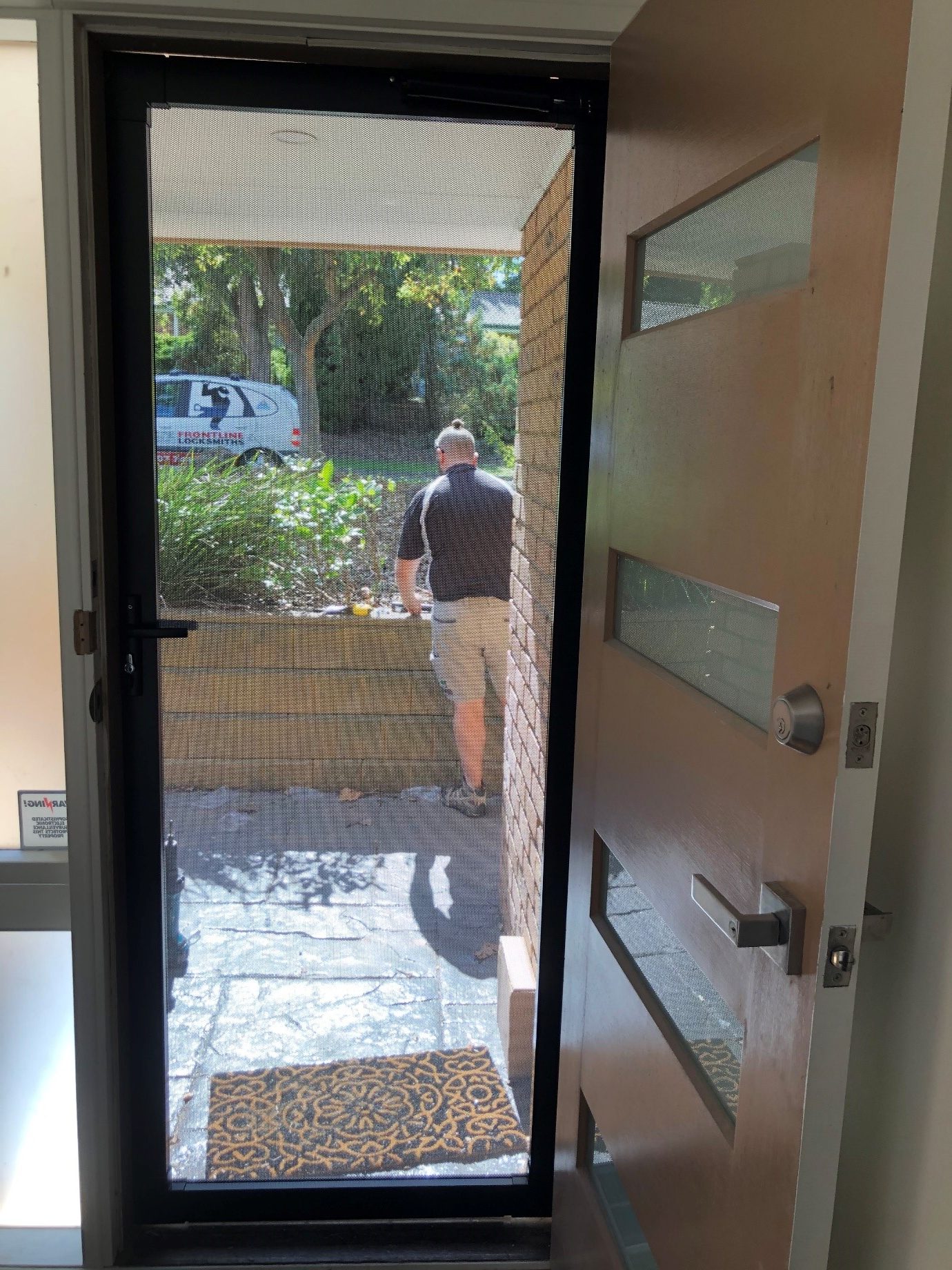 Locksmith inspecting worn residential door lock to determine rekey or replacement in Melbourne home