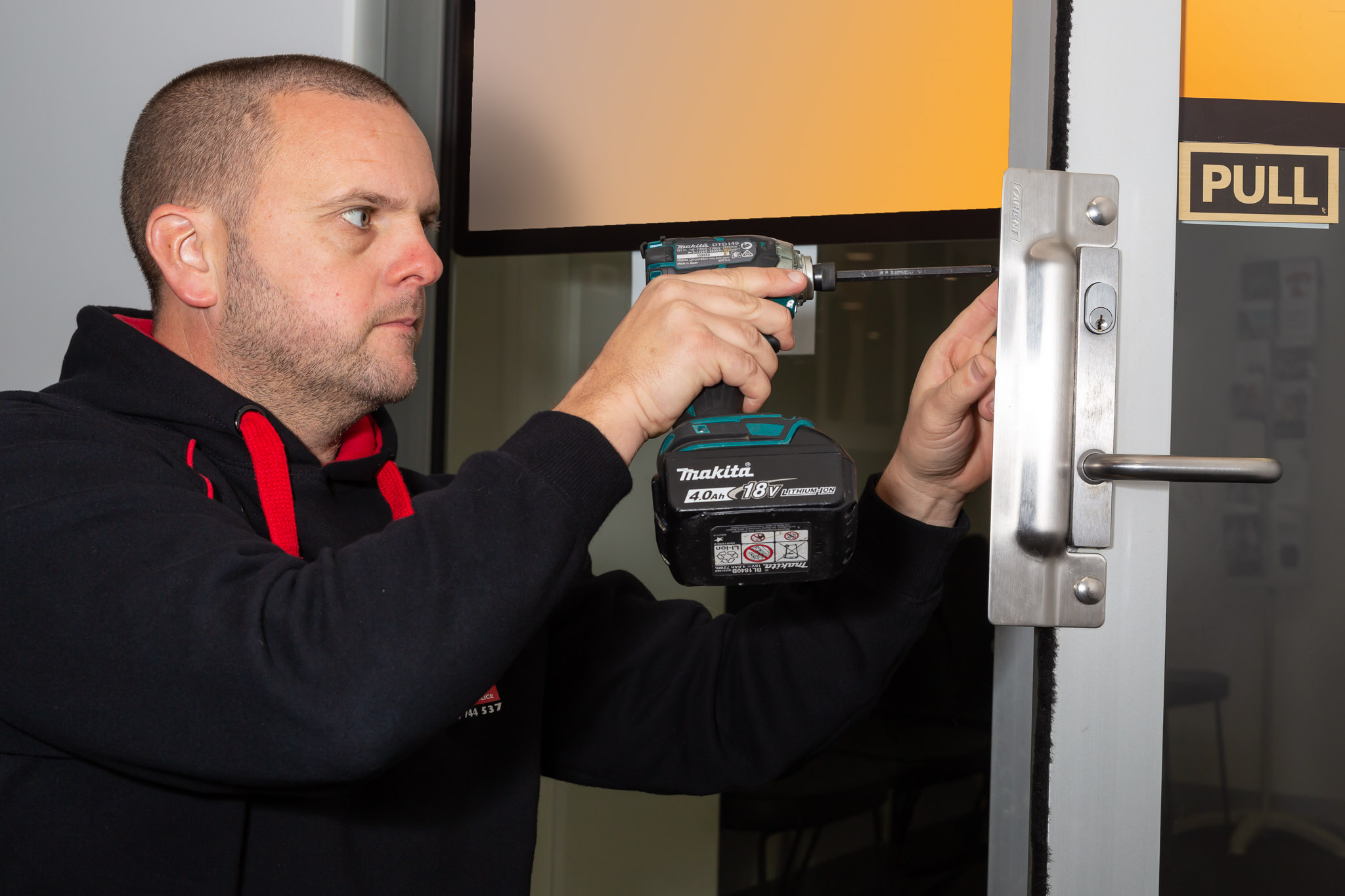 Installing commercial-grade lock hardware on a glass entry door, Manningham Medical Centre